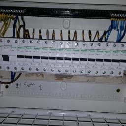 lemar - Otwarta skrzynka rozdzielcza z zainstalowanymi bezpiecznikami Schneider Electric, widoczne przewody w różnych kolorach i oznaczenia C10, C20, 25A, oraz napis '21 Soder I' na dolnej części obudowy.