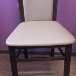 Produkcja i Renowacja Mebli BESUTO - Krzesło z ciemnego drewna z jasną, tapicerowaną powierzchnią siedziska i oparcia, na tle fioletowej ściany i drewnianej podłogi.