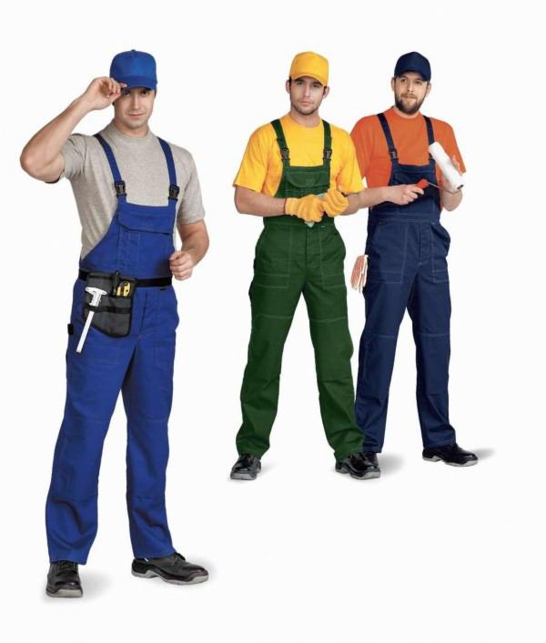 Trzech mężczyzn w roboczych kombinezonach i czapkach, jeden z pasem narzędzi, drugi z wałkiem do malowania, prezentacja odzieży roboczej.