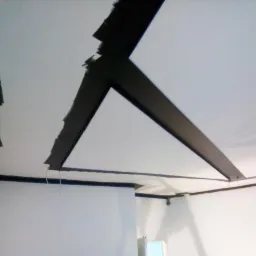 Fragment pomalowanego sufitu z dekoracyjnymi, czarnymi belkami w kształcie trójkąta, widoczne niedociągnięcia malarskie przy krawędziach belek.