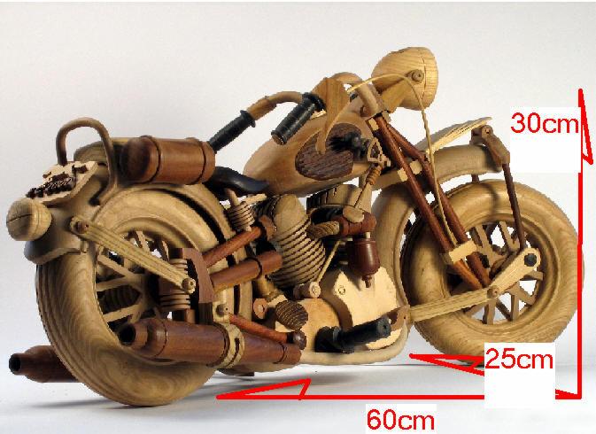 Drewniany model motocykla z widocznymi elementami konstrukcyjnymi, wykonany z jasnego drewna, na białym tle.