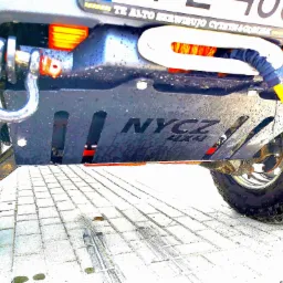 Zamontowana wyciągarka samochodowa z liną i hakiem, widok od dołu na tle kostki brukowej.