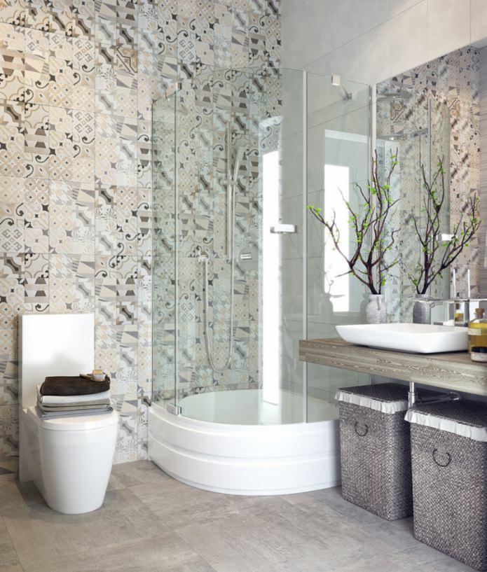 Wykończona łazienka z kabiną prysznicową narożną, wzorzystymi płytkami ceramicznymi na ścianie i toaletą z ułożonymi ręcznikami.