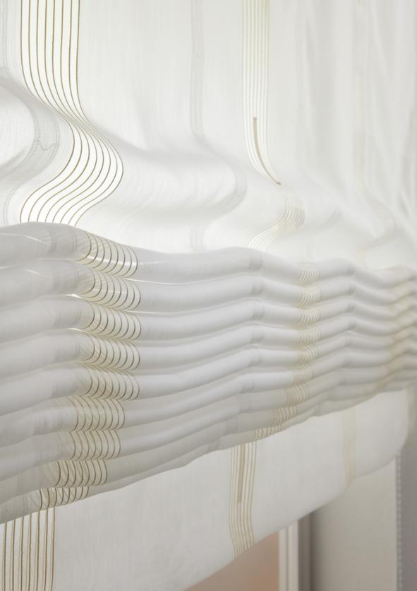 Delikatna, biała zasłona rzymska z subtelnymi, pionowymi paskami w odcieniach beżu, tworząca miękkie, poziome fałdy.