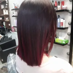 Średniej długości, proste włosy w kolorze ciemnej wiśni z widocznymi refleksami w salonie.