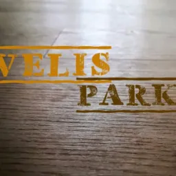 Zbliżenie na ułożoną podłogę z paneli imitujących drewno, z nałożonym efektem graficznym z napisem 'VELLIS PARK'.