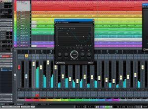 Ekran komputera z otwartym programem do miksowania audio, widoczne suwaki, wskaźniki poziomu dźwięku i okno equalizera z wykresem sinusoidalnym na czarnym tle.