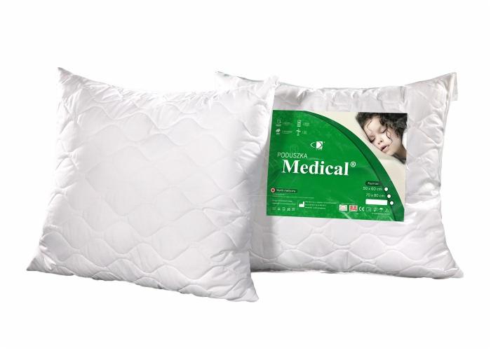 Dwie białe poduszki medyczne z pikowanym wzorem, jedna z etykietą informacyjną z zielonym akcentem i zdjęciem śpiącego dziecka.