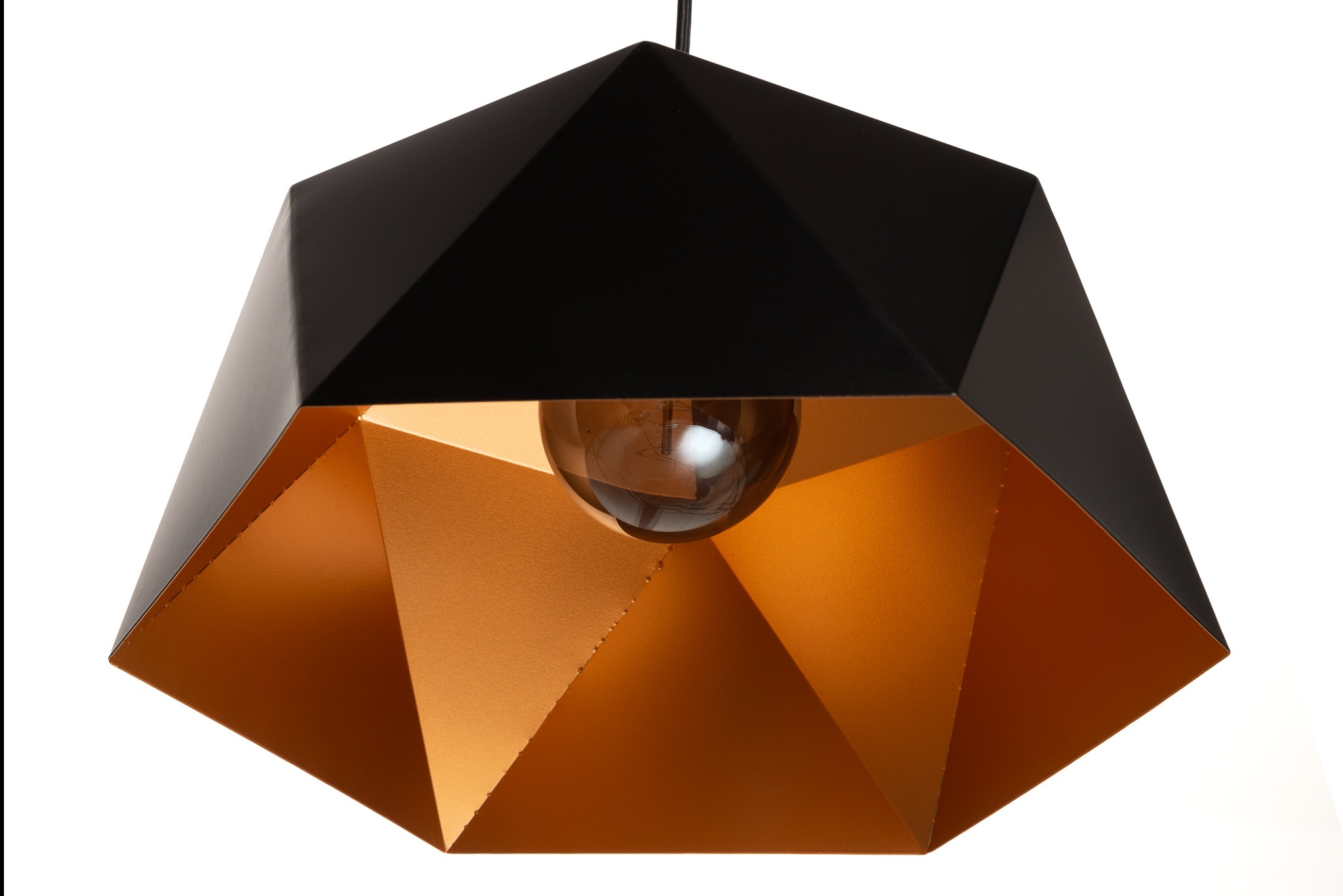 Czarno-złota lampa wisząca o geometrycznym kształcie, z widoczną żarówką, na białym tle. Minimalistyczny design, ostre krawędzie, ciepłe światło odbijające się od złotego wnętrza.