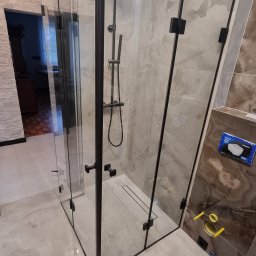 F.P.H.U. EK-GLASS Beata Kocoń - Nowoczesna kabina prysznicowa z czarnymi profilami w Mszanie Dolnej. Szklane ściany, deszczownica i armatura w kolorze czarnym. Widoczny odpływ liniowy w podłodze.