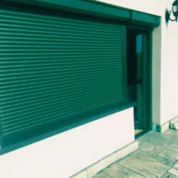 Zamknięta, zielona osłona okienna na elewacji budynku z oknem i ozdobnym oświetleniem zewnętrznym.