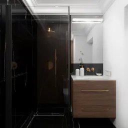 Nowoczesna łazienka z czarną kabiną prysznicową z marmurowym wzorem, złotą armaturą i drewnianą szafką pod umywalką z białym blatem.