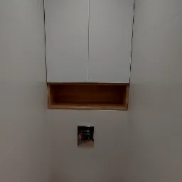 Nowoczesna, wąska łazienka z podwieszaną toaletą, szafką na wymiar nad nią i drewnianą półką, oświetlona punktowym światłem.