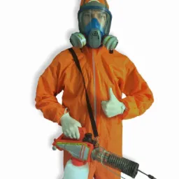 Osoba w pomarańczowym kombinezonie ochronnym i masce gazowej, trzymająca zamgławiacz termiczny Mini-Mist Fogger KB-100, kciuk w górę na białym tle.