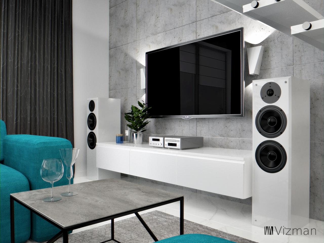 Nowoczesny salon z betonową ścianą, białymi głośnikami i turkusową sofą, stolik kawowy z dwoma kieliszkami.