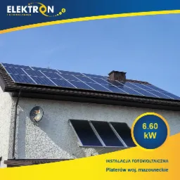 Instalacja paneli słonecznych na dachu domu o mocy 6.60 kW, z dodatkowymi panelami na ścianie. Widok z dołu na błękitne niebo.