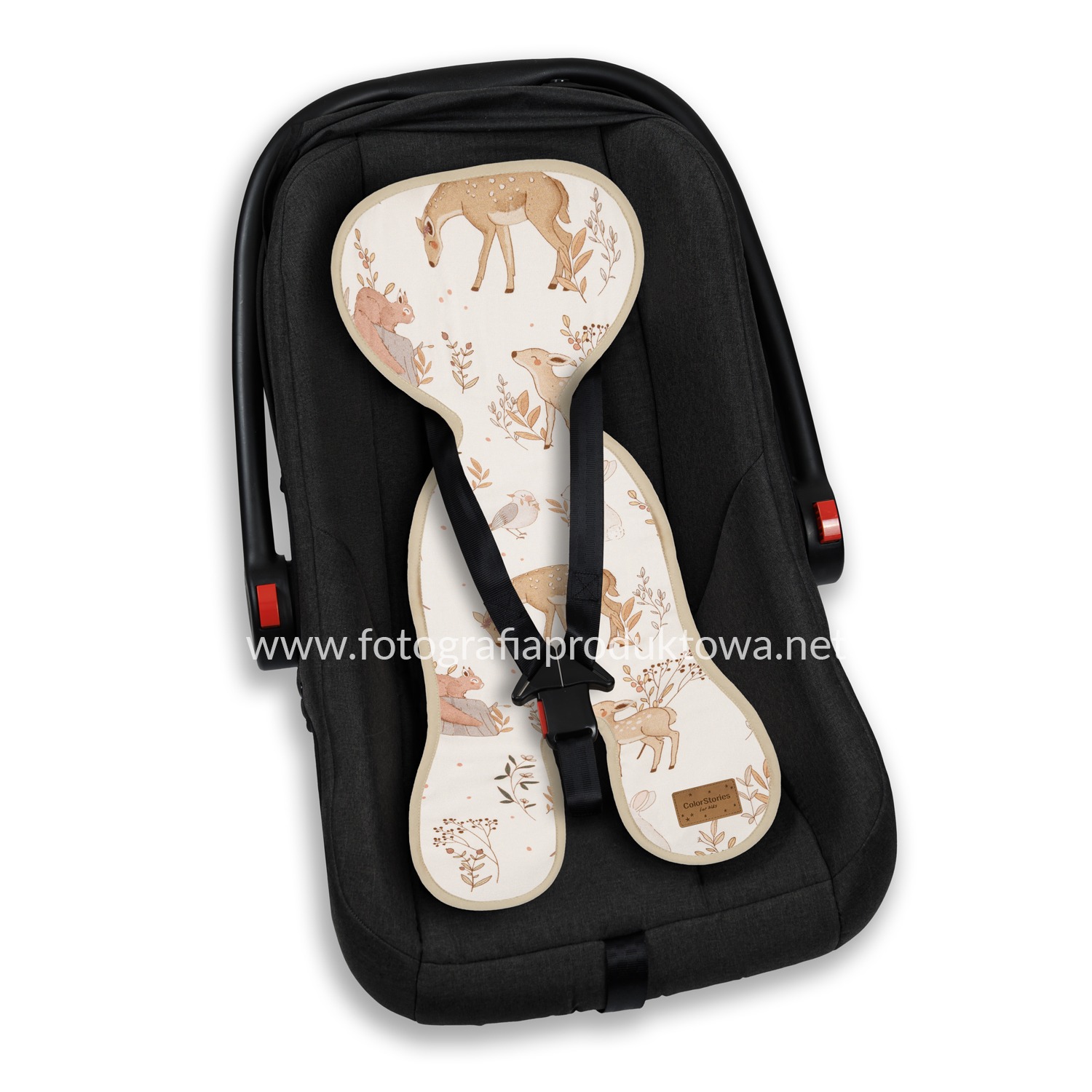 Fotografia produktowa: Czarny fotelik samochodowy dla dziecka z wkładką w beżowe leśne zwierzęta, widoczne detale i faktura materiału.