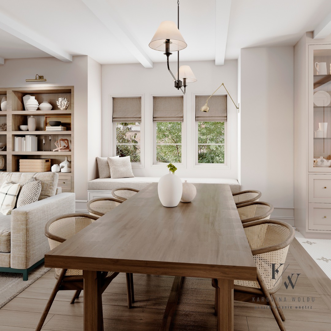 Jasne wnętrze jadalni z drewnianym stołem, wiklinowymi krzesłami, wazonami na stole i oknem z siedziskiem w tle.
