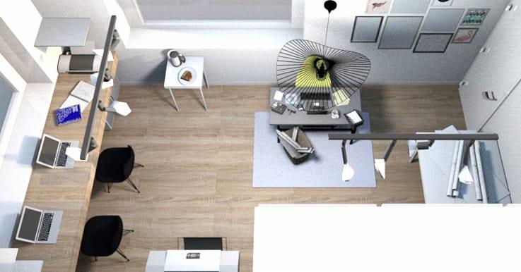 Widok z góry na przestrzeń biurową z drewnianą podłogą, biurkami z laptopami, czarnymi krzesłami, lampą wiszącą w stylu industrialnym i dekoracjami ściennymi, ukazujący aranżację wnętrza.