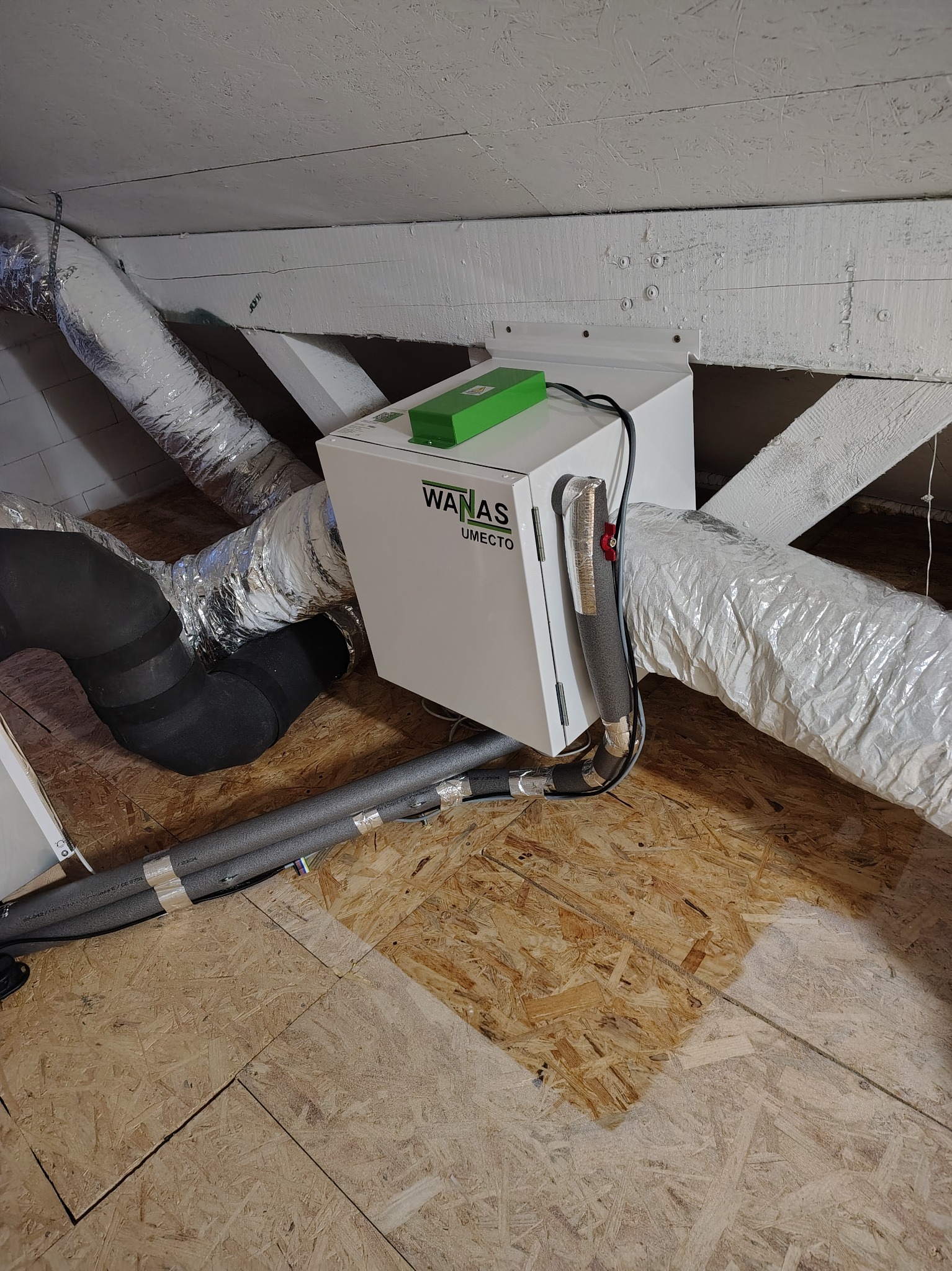 Centrala rekuperacyjna Waneco Umecto zamontowana na poddaszu, widoczne rury wentylacyjne i elementy konstrukcji dachu.