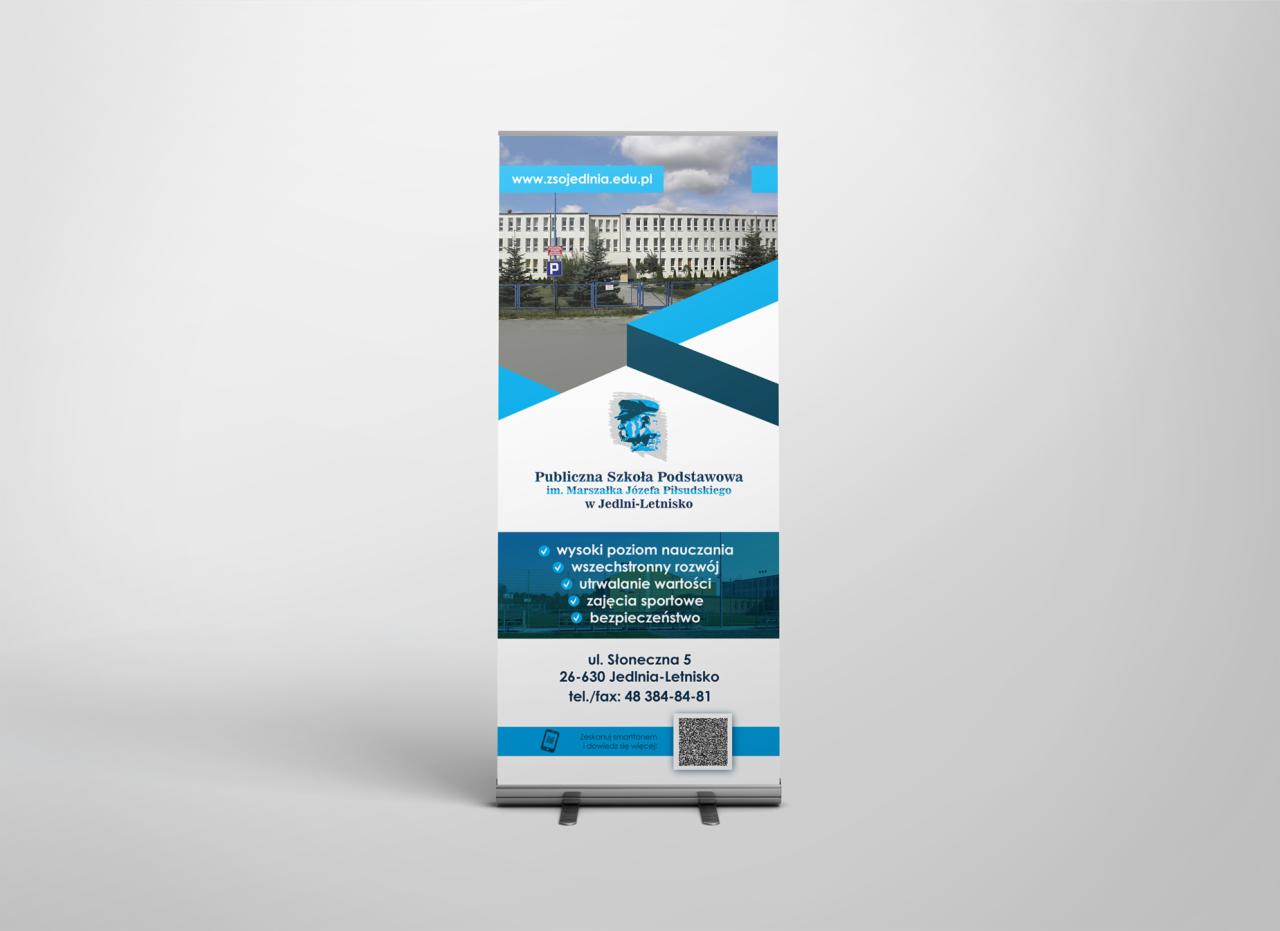 Roll-up reklamowy z wizualizacją budynku Publicznej Szkoły Podstawowej w Jedlni-Letnisku, adres strony internetowej i QR kod.