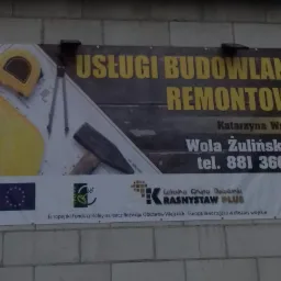 Baner reklamowy firmy budowlano-remontowej z Woli Żulińskiej, z narzędziami kreślarskimi, młotkiem i miarką na tle ceglanej ściany.