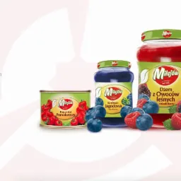 Prezentacja wizualizacji marki Milejów: dżem z owoców leśnych, konfitura jagodowa, koncentrat pomidorowy w puszce, otoczone świeżymi jagodami i malinami na białym tle z logo Red Baron w prawym...