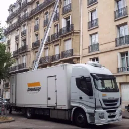 Ciężarówka firmy Hasenkamp z wysuwaną platformą do okna budynku w Paryżu, podczas transportu mebli.