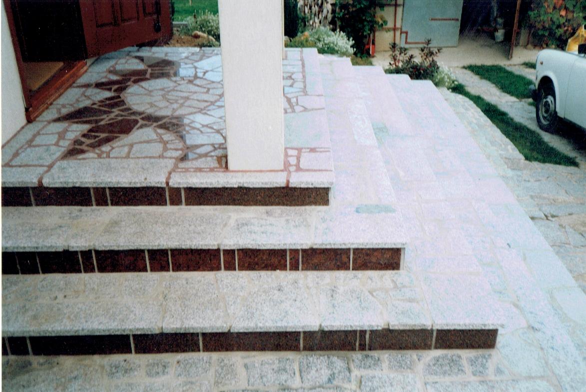 Kamienne schody wejściowe z mozaiką na podłodze w Sobótce, prowadzące do domu z białą kolumną.