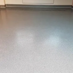 Posadzka w garażu - mix piasków w kolorze szarym zamkniętych bezbarwną żywicą.