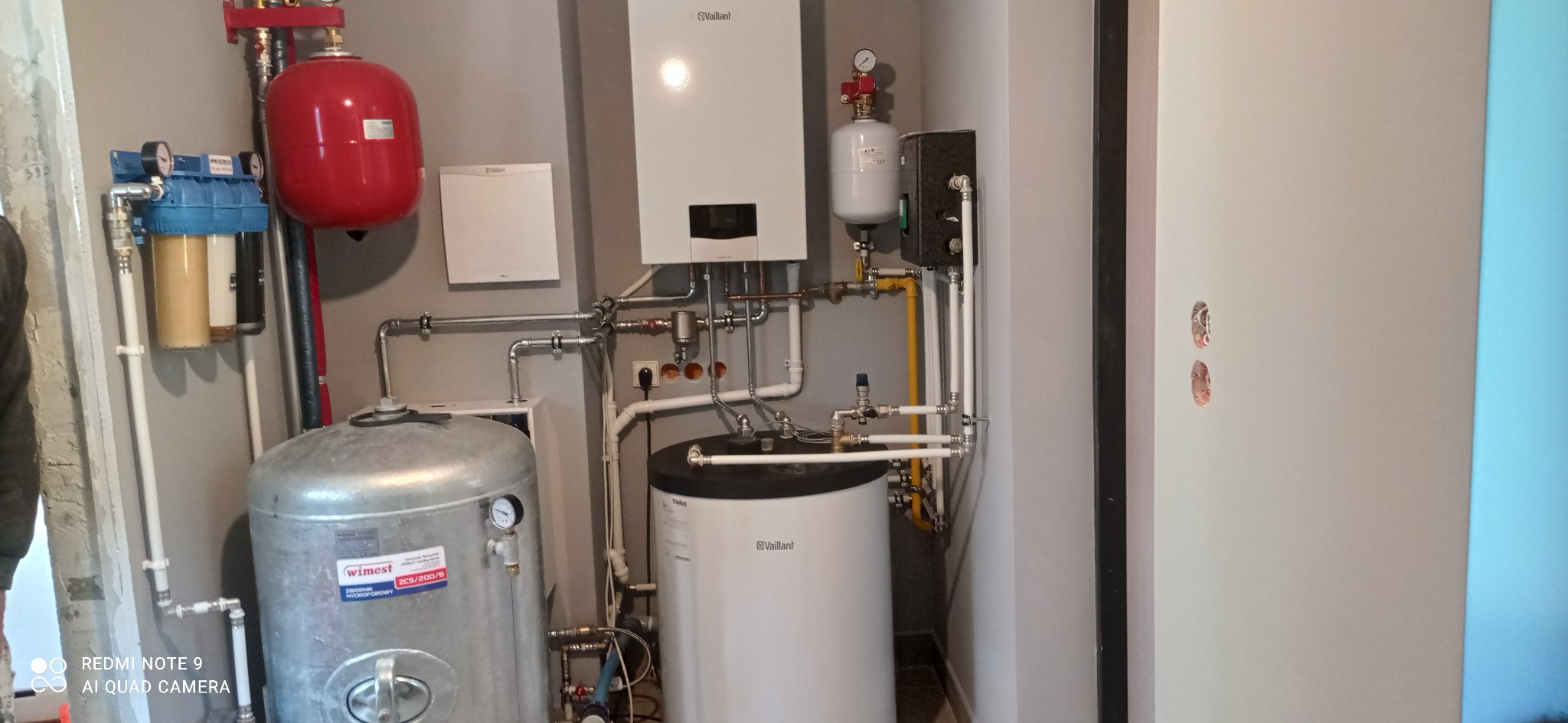 Kotłownia z zamontowanym piecem gazowym Vaillant, zbiornikiem hydroforowym Wimest, filtrami wody i rozbudowaną instalacją hydrauliczną z rur miedzianych i stalowych.