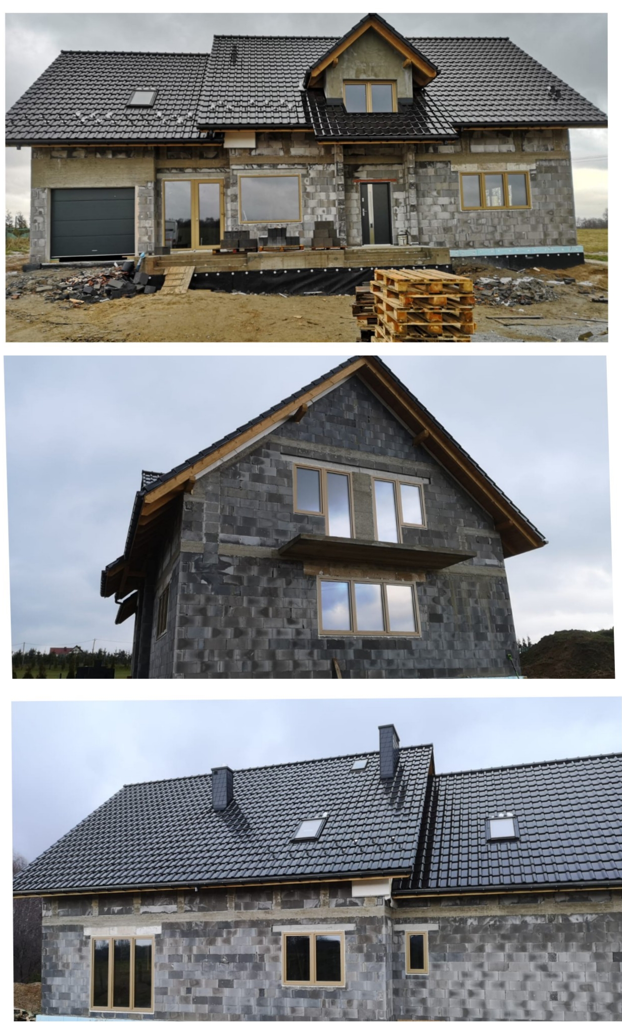 Dom w trakcie budowy z szarych bloczków, z zamontowanymi oknami w drewnianych ramach i ciemną bramą garażową, widok na plac budowy z paletami i materiałami budowlanymi.