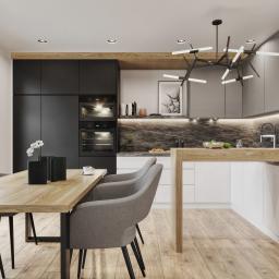 Osky Justyna Knapek - Nowoczesna kuchnia z drewnianym blatem i stołem, czarne i szare szafki, designerska lampa wisząca, drewniana podłoga, minimalistyczny wystrój.