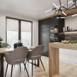 Osky Justyna Knapek - Jasna kuchnia z drewnianymi akcentami, czarnymi szafkami i nowoczesnym oświetleniem, stół z szarymi krzesłami i rośliną doniczkową przy oknie.