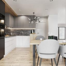 Osky Justyna Knapek - Nowoczesna kuchnia z czarnymi, szarymi i białymi szafkami, marmurowym blatem, drewnianym akcentem na suficie i minimalistycznym oświetleniem, uzupełniona o stół jadalny z szarymi krzesłami...