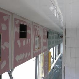 Remonter - Montaż klimatyzacji w ścianie z płyt kartonowo-gipsowych, widoczne ślady szpachlowania i łączenia płyt, sufit z białych płytek.