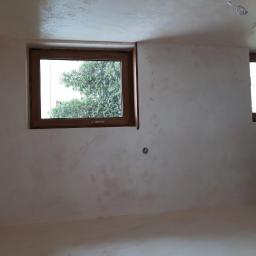 Remonter - Pokój po wykonaniu gładzi w odcieniach beżu i brązu, z dwoma oknami z drewnianymi ramami.