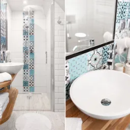 Jasna łazienka z kabiną prysznicową, białą umywalką na drewnianym blacie i dekoracyjnymi płytkami w odcieniach błękitu i szarości.