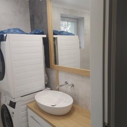 ROBERT DAWID - Nowoczesna łazienka z pralką i suszarką w zabudowie, umywalką nablatową na szafce z blatem drewnianym i lustrem w drewnianej ramie.