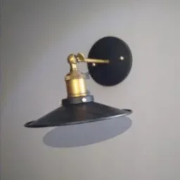 Czarny, metalowy kinkiet ścienny w stylu industrialnym z mosiężnymi elementami, zamontowany na szarej ścianie. Widoczny cień rzucany przez lampę.