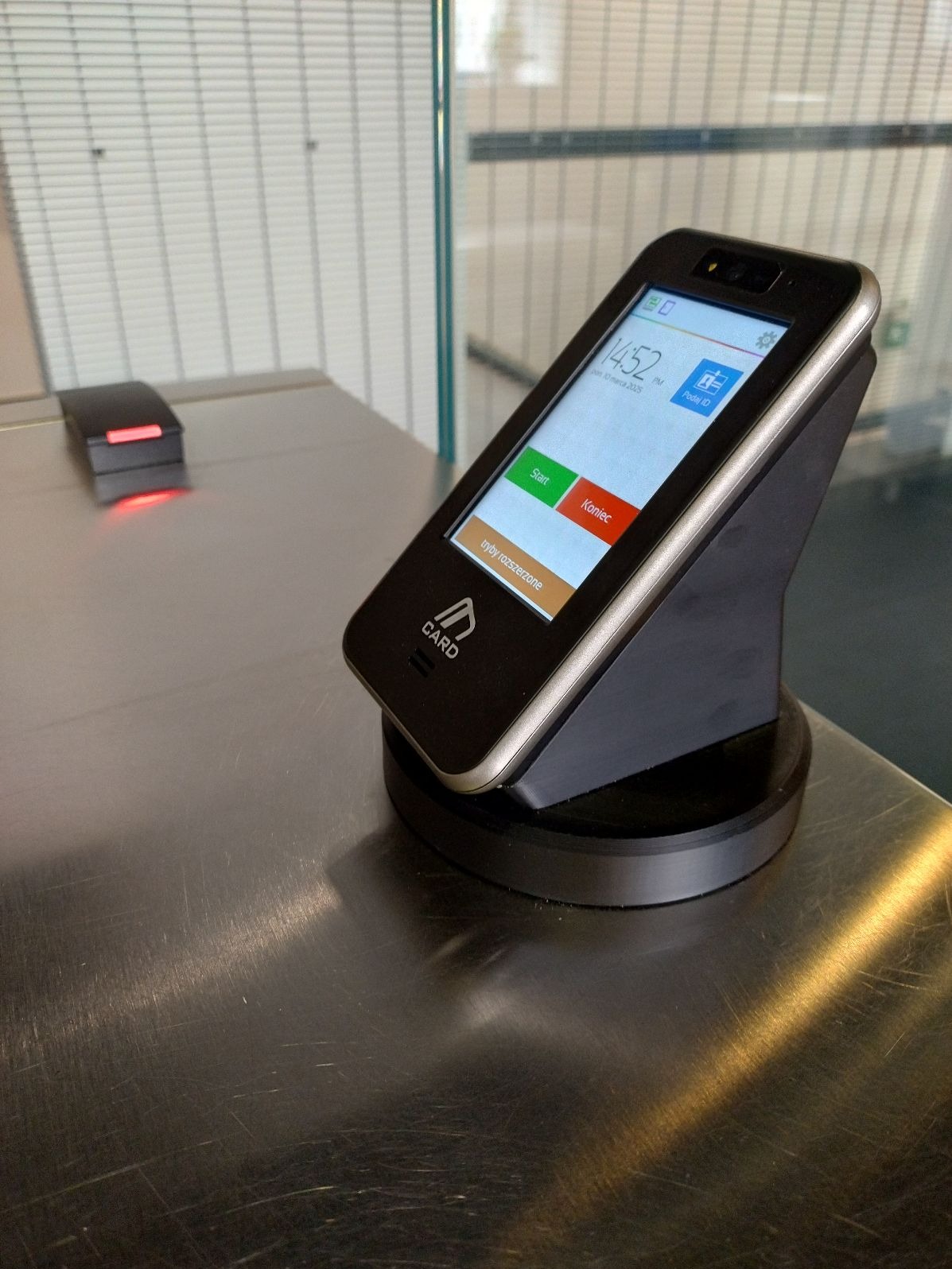 Terminal kontroli dostępu z ekranem dotykowym i czytnikiem kart na metalowym blacie, widoczny przycisk 'Start' i 'Koniec'.