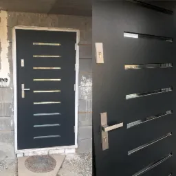 Grafitowe drzwi wejściowe z poziomymi przeszkleniami, zamontowane w surowym otworze murowanym, widok z bliska na klamkę i zamek.