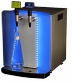 Dystrybutor wody Brita Vivreau Mini Bottler z podświetleniem LED, napełniający szklaną butelkę. Widoczne dwie dysze do wody gazowanej i niegazowanej.