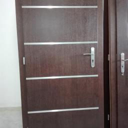 Drewniane drzwi wewnętrzne z metalowymi paskami