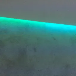 Ściana z dekoracyjną, liniową iluminacją LED w odcieniach zieleni i błękitu, skierowaną w dół.