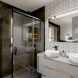 Nowoczesna łazienka z podwójną umywalką nablatową, czarną armaturą, kabiną prysznicową typu walk-in i geometrycznymi płytkami na ścianie. W lustrze odbija się pralka i szafki.