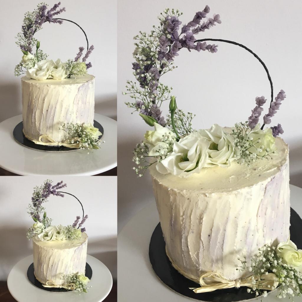 Tort z kremem o fakturze kory drzewa, udekorowany kompozycją z białych róż, gipsówki, lawendy i czarnego okręgu, prezentowany na białym tle w trzech ujęciach.