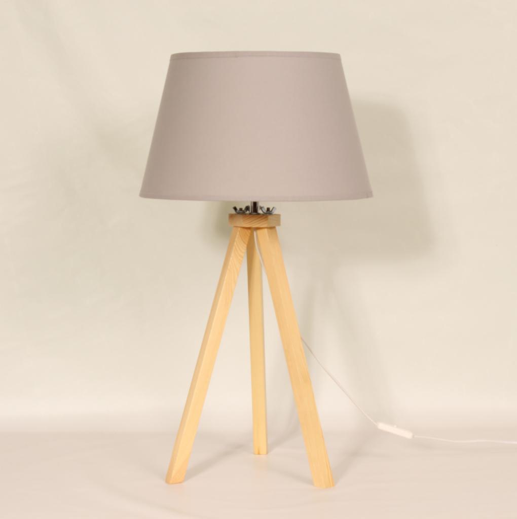 Lampa stołowa z szarym abażurem i drewnianym trójnożnym stelażem na białym tle.