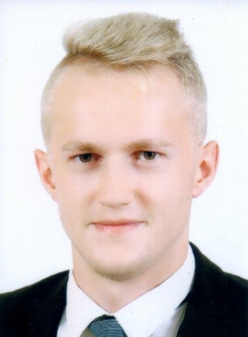 Portret młodego mężczyzny w garniturze, z jasnymi włosami zaczesanymi do góry i lekko uśmiechniętą twarzą na białym tle.