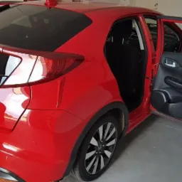 Czerwony samochód Honda Civic z otwartymi tylnymi drzwiami, widoczny numer rejestracyjny RP 51888.